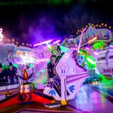 Besucher der Palmkirmes in Recklinghausen sitzen im Fahrgeschäfte „Shake and Roll“