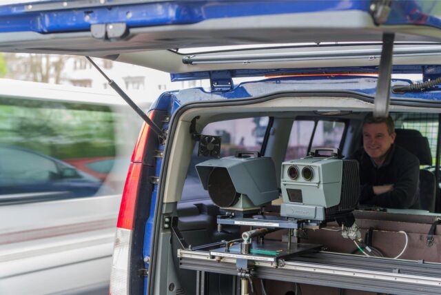Ein Ordnungsamt-Mitarbeiter sitzt in einem städtischen Radarwagen mit offenem Kofferraum