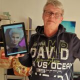 Frank G. aus Dortmund hält ein Tablet mit einem Foto von FDP-Politikerin Marie-Agnes Strack-Zimmermann in einem Karnevalskostüm.