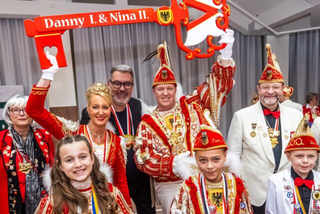 Menschen feiern Karneval auf einer Bühne.