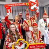 Menschen feiern Karneval auf einer Bühne.