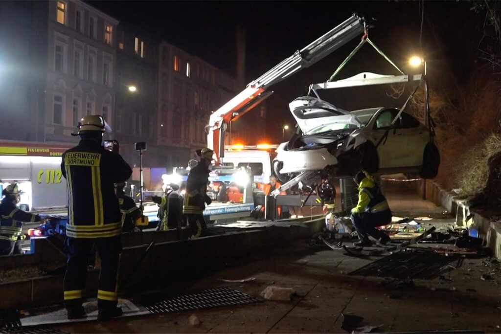 Eindrücke von der Unfallstelle an das Fassstraße in Dortmund: Der stark demolierte Tesla blieb in der Böschung liegen, wurde per Kran geborgen. An der Unfallstelle liegen viele Trümmerteile.