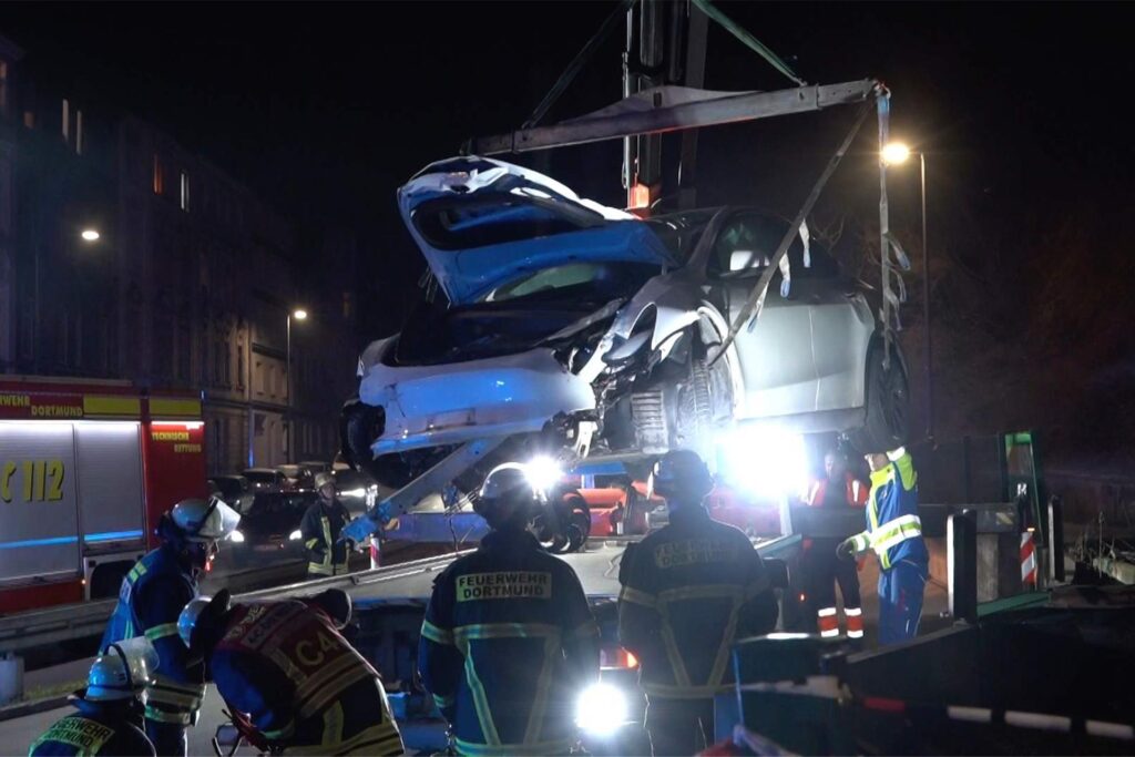 Eindrücke von der Unfallstelle an das Fassstraße in Dortmund: Der stark demolierte Tesla blieb in der Böschung liegen, wurde per Kran geborgen. An der Unfallstelle liegen viele Trümmerteile.