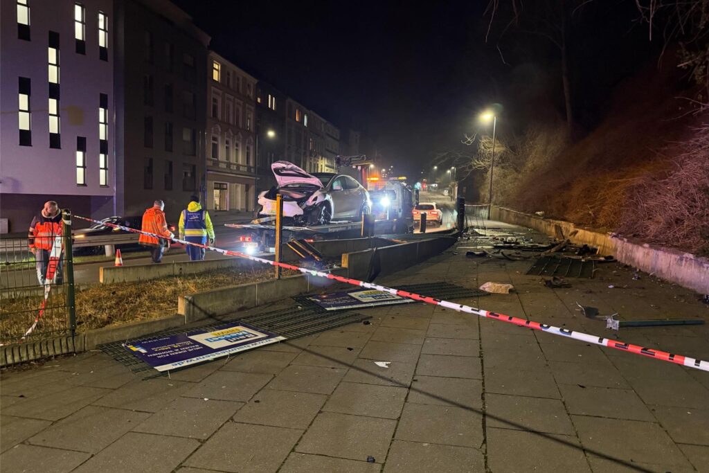 Eindrücke von der Unfallstelle an das Fassstraße in Dortmund: Der stark demolierte Tesla blieb in der Böschung liegen, wurde per Kran geborgen. An der Unfallstelle liegen viele Trümmerteile.