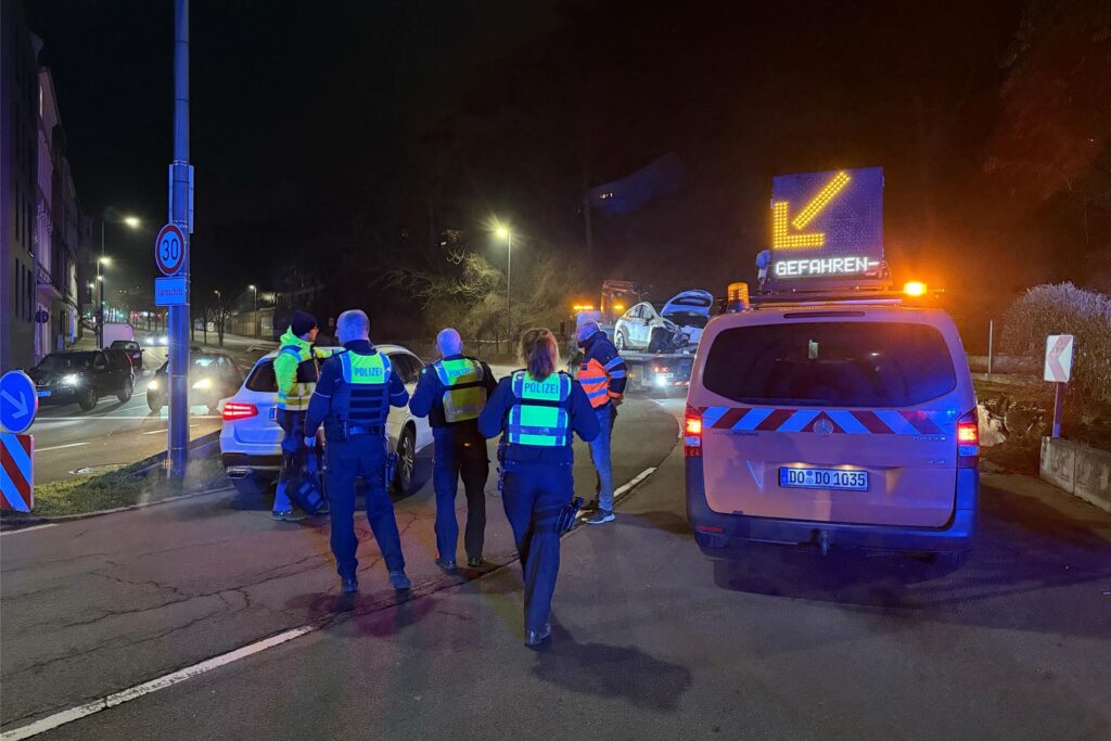Eindrücke von der Unfallstelle an das Fassstraße in Dortmund: Der stark demolierte Tesla blieb in der Böschung liegen, wurde per Kran geborgen. An der Unfallstelle liegen viele Trümmerteile.