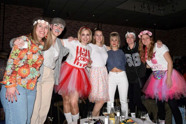 Eine Gruppe verkleideter Frauen steht bei der Sause der Karneval Gesellschaft Herten-Langenbochum auf Stühlen und schunkelt.