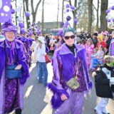 Eine lilafarben kostümierte Fußgruppe beim Karnevalsumzug.