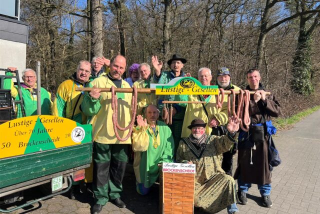 Die lustigen Gesellen (Brockenscheidt) stehen neben einem Kastenwagen.