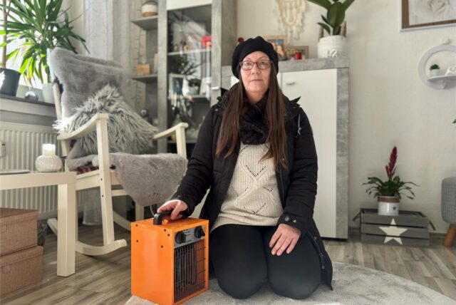 Janett Sachweh sitzt mit einem Heizlüfter in ihrem Wohnzimmer.