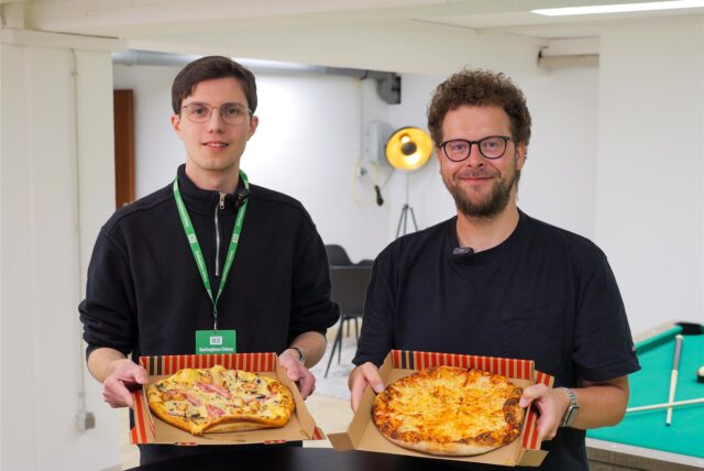 Die RZ-Reporter Valentin Schneider und Christian Pozorski stehen mit Pizzen in der Redaktion der Recklinghäuser Zeitung.