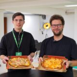 Die RZ-Reporter Valentin Schneider und Christian Pozorski stehen mit Pizzen in der Redaktion der Recklinghäuser Zeitung.