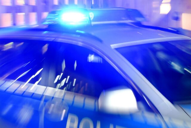 Ein Streifenwagen der Polizei steht mit eingeschaltetem Blaulicht auf der Straße.