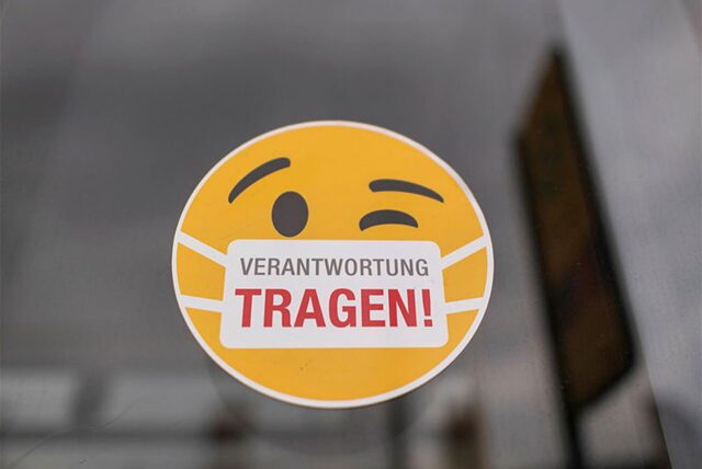 Ein gelber Smiley mit Maske und der Aufschrift „Verantwortung tragen!“