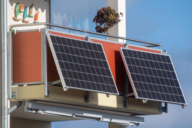 Zwei Solarmodule hängen an einem Balkon.