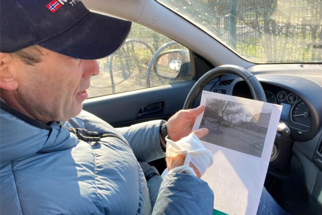 Volker Schulte im Walde sitzt in seinem Auto und hält den Ausdruck eines Fotos in der Hand, auf dem ein Parkplatz in Herten-Westerholt zu sehen ist.
