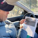 Volker Schulte im Walde sitzt in seinem Auto und hält den Ausdruck eines Fotos in der Hand, auf dem ein Parkplatz in Herten-Westerholt zu sehen ist.