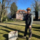 Ein Mann steht auf dem Vorplatz der St. Marien-Kirche in Waltrop und hält ein Seil in der rechten Hand.