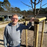 Michael Falkenreck, Leiter der Jugendherberge in Haltern am See, steht an einem Baum vor Holzbungalows.