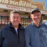 Richard Abendroth (1. Vorsitzender des Schaustellervereins Recklinghausen) und Thorsten Philipp (Schausteller) stehen vor Stand mit gebrannten Mandeln