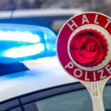 Eine Polizeikelle und im Hintergrund ein Streifenwagen