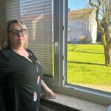 Melanie Huck steht vor ihrem geöffneten Wohnzimmerfenster in der Dogewo-Siedlung in Eving.