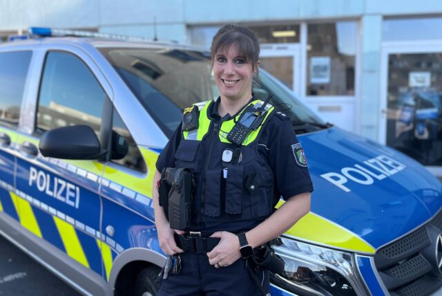 Corinna Kutschke steht vor einem Dienstwagen der Polizei vor der Polizeiwache in Dorsten.