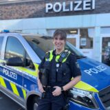 Corinna Kutschke steht vor einem Dienstwagen der Polizei vor der Polizeiwache in Dorsten.