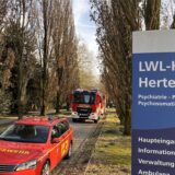 In der Zufahrt zur LWL-Klinik Herten stehen Einsatzfahrzeuge der Hertener Feuerwehr.