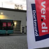 Ein Bus steht auf einem Betriebshof. In der Scheibe steht auf zwei Zetteln „Warnstreik“.