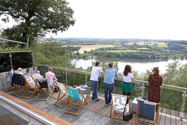 Besucher stehen im Biergarten am Jagdhaus Schellenberg in Essen und blicken auf den Baldeneysee.