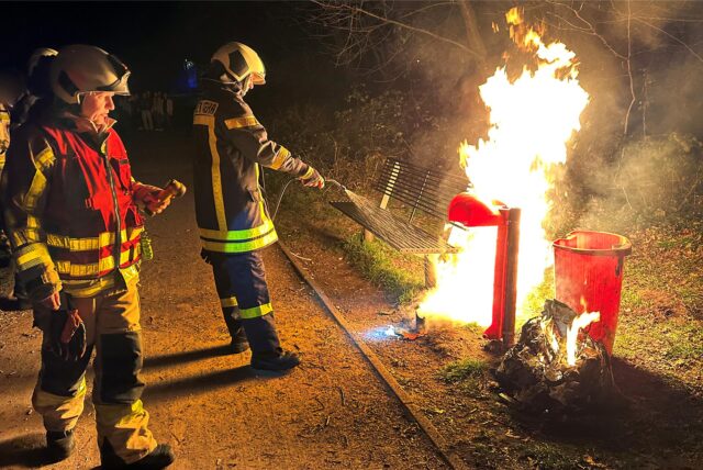 Feuerwehrleute löschen einen brennenden Müllcontainer in Dorsten.