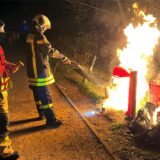 Feuerwehrleute löschen einen brennenden Müllcontainer in Dorsten.