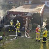 Feuerwehrleute löschen am Sonntagnachmittag ein brennendes Carport.