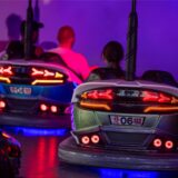 Personen fahren Autoscooter auf einer Kirmes.