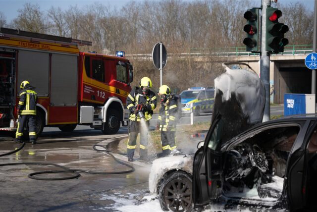 Die Feuerwehr Marl löscht einen brennenden Audi an einer Autobahnabfahrt in Marl-Brassert.
