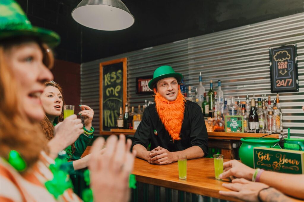 Ein Mann und zwei Frauen stehen in einer Bar und feiern den St. Patrick's Day. Ein Mann und zwei Frauen stehen in einer Bar und feiern den St. Patrick's Day.