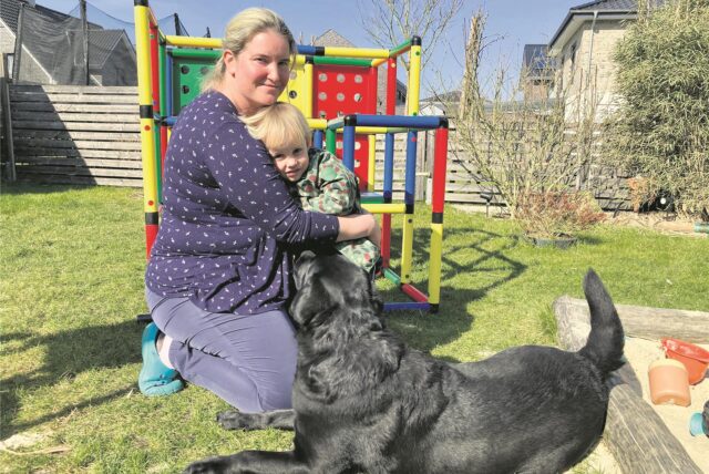 Tagesmutter Jennifer Krieger mit Sohn Quentin im Garten. Davor hockt Hund „Arti“.