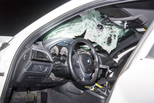Zersplittert hängt die Windschutzscheibe eines BMWs nach der Kollision mit einem großen Stein im Rahmen. (Symbolbild)