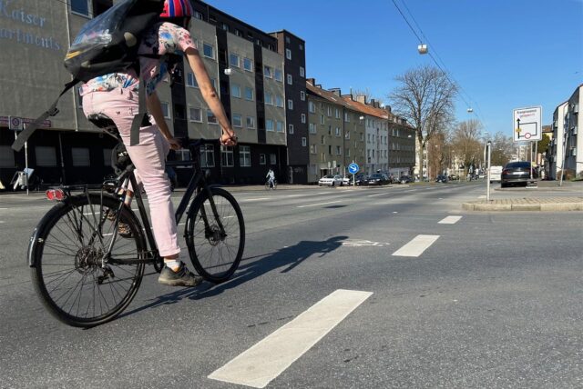 Eine Radfahrerin fährt auf dem Heiligen Weg.