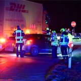 Feuerwehrleute stehen um einen verunfallten Pkw.