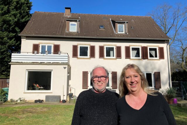 Stephanie und Olaf Freund stehen im großen Garten ihres Hauses in der Bereitschaftssiedlung in Marl.