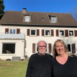 Stephanie und Olaf Freund stehen im großen Garten ihres Hauses in der Bereitschaftssiedlung in Marl.