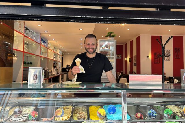 Betreiber Bruno Jesus steht hinter der Theke der Eisdiele „MiDA“ in Datteln und hält ein Eis in der Hand.