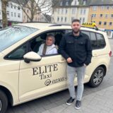 Esra Oruc und ein Mitarbeiter stehen an ihrem Taxi des Taxiunternehmens Elite aus Castrop-Rauxel.