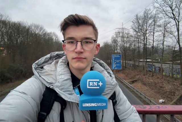 RN-Reporter Julius Obhues steht mit einem Mikrofon auf einer Brücke der A45. Unter ihm fahren Autos entlang.