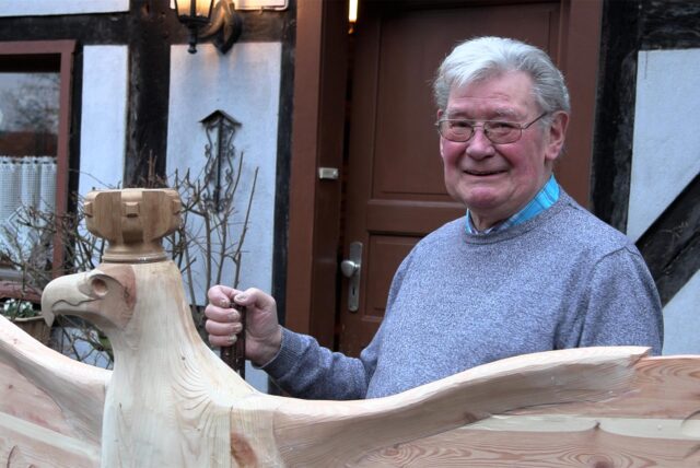 Hubert Brüggemann aus Waltrop steht vor seinem Hof und zeigt den Schützenvogel aus Holz.