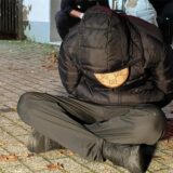 Ein junger Mann sitzt auf dem Boden. Er wurde festgenommen.