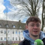 Vincent Rastfeld steht vor der Harkortschule in Marl. Auf dem Dach der Schule befindet sich eine der 22 Warnsirenen aus Marl.