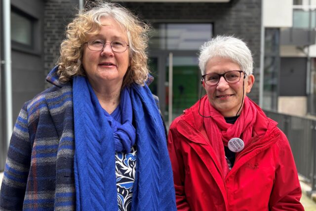Brigitte Mues-Hölscher und Christa Volkmann stehen nebeneinander vor einer Fassade