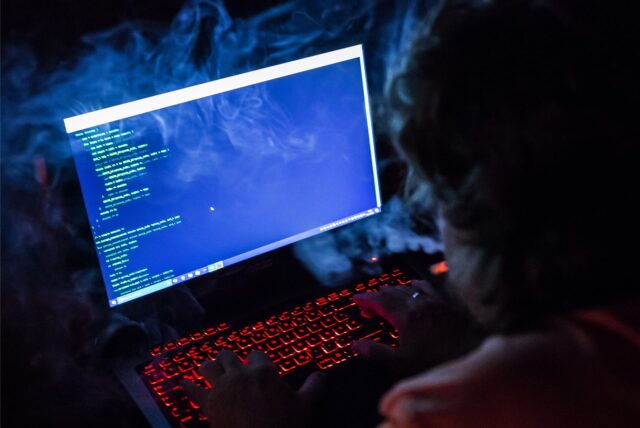 Eine Person blickt auf einen Laptop mit einer beleuchteten Tastatur.